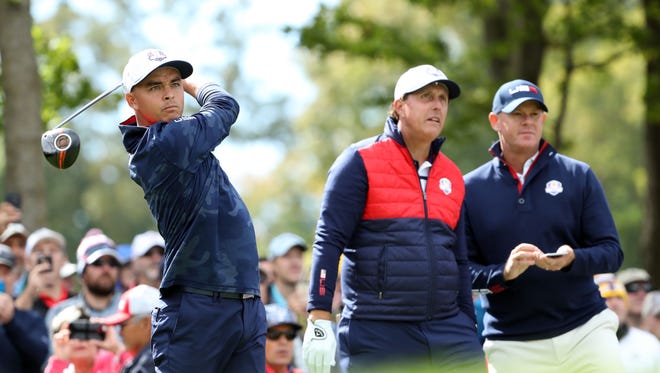 Rickie Fowler plays his shot from the sixth tee as  Phil Mickelson watches during a practice for the 41st Ryder Cup at Hazeltine National Golf Club on Sept. 27.