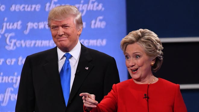 Democratic presidential candidate Hillary Clinton and Republican presidential candidate Donald Trump stand on stage before the first presidential debate at Hofstra University.