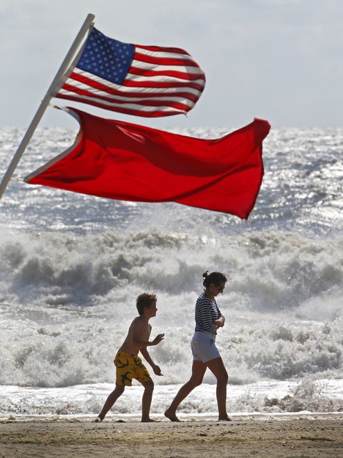 Beachgoers walk away from big waves and rough surf caused by Hermine on Sept. 4, 2016, in Bradley Beach, N.J. No swimming was allowed because of the passing storm.