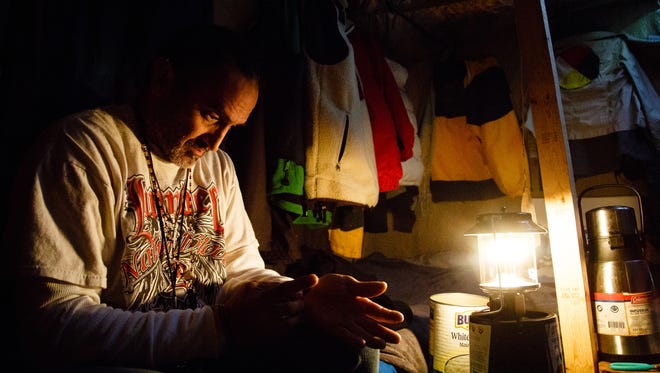 Popz Longwalker puts on his native jewelry in the hut he and his wife, Dawne of a new day DuShane, share in the Oceti Sakowin Camp on Monday, Dec. 5, 2016 near Cannon Ball. The couple left home in Norman, Okla., and put what they had in storage saying they just taking it a day at a time here.
