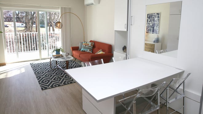 The bed is folded up into the wall so the dining table can be used in this studio apartment on the fourth floor.
