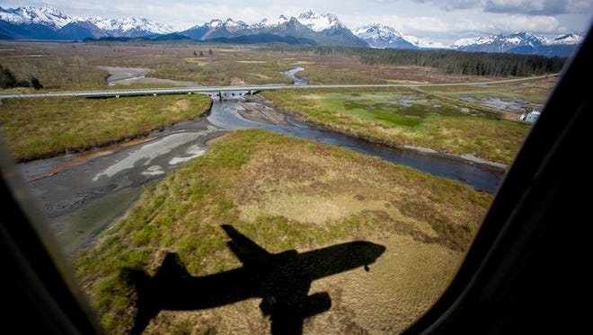Moments from landing, an Alaska Airlines Boeing 737-800 casts a deep shadow over a beautiful Alaskan landscape near Cordova, Alaska, on May 14, 2015.