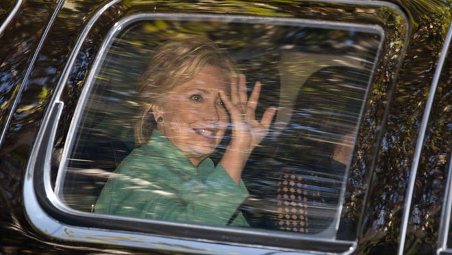 Hillary Clinton waves from her motorcade vehicle in Los Angeles Aug. 23, 2016.