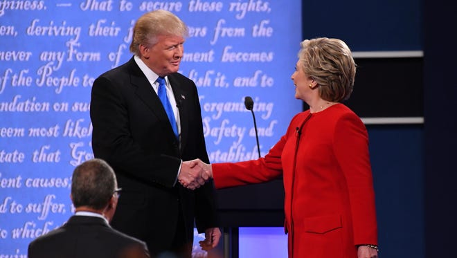 Democratic presidential candidate Hillary Clinton greets Republican presidential candidate Donald Trump on stage during the first presidential debate at Hofstra University. Moderator Lester Holt from NBC is bottom left.