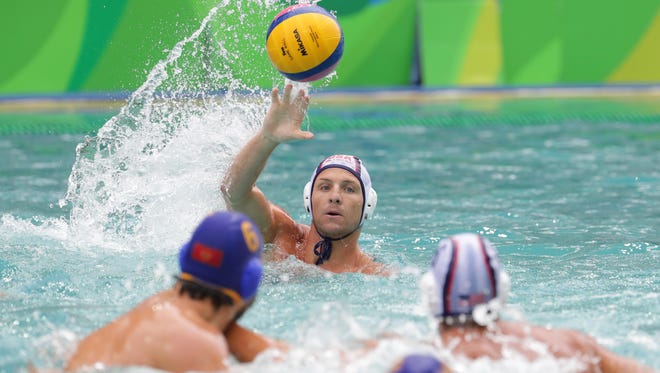 Tony Azevedo of the United States throws the ball against Montenegro during a men's water polo preliminary round game in the Rio 2016 Summer Olympic Games at Maria Lenk Aquatics Centre.