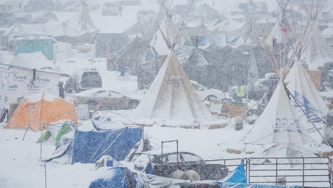 The Oceti Sakowin Camp sits covered in snow as more continues to fall on Monday, Dec. 5, 2016, near Cannon Ball.