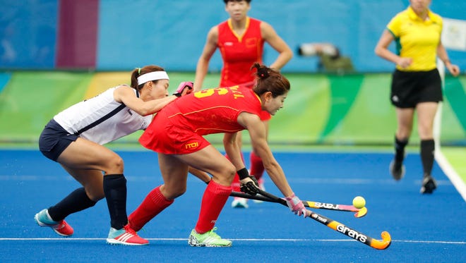 Jiaojiao De of China plays the ball against Korea during a women's field hockey first round pool game in the 2016 Rio Summer Olympic Games at Olympic Hockey Centre.