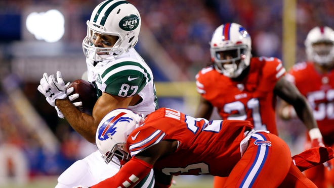 New York Jets wide receiver Eric Decker (87) is tackled by Buffalo Bills strong safety Aaron Williams (23) after making a catch during the first half at New Era Field.
