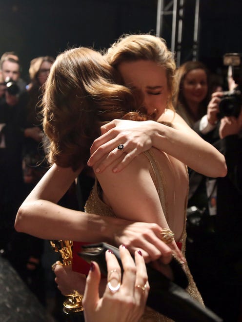 Brie Larson, back, embraces Emma Stone, winner of the award for best actress in a leading role for "La La Land," backstage at the Oscars.