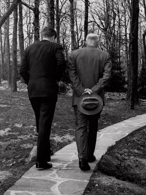 President John F. Kennedy, left, discusses the failed Bay of Pigs invasion with former president Dwight D. Eisenhower as they walk along a path at Camp David on April 22, 1961.