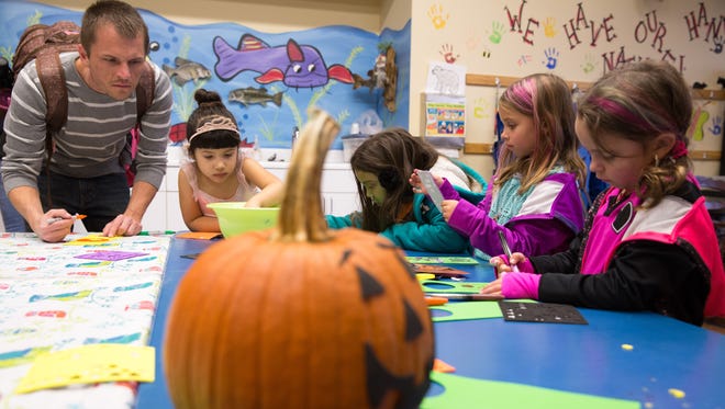 Taylor Dailey (from left), Gianna Ludwig, 5, both of West Des Moines, Kiera Baccam, 5, Chloe Michaels, 6, and Calie Michaels, 5, all of Altoona, make crafts Friday, Oct. 23, 2015, during Halloween Hoopla at Raccoon River Park in West Des Moines.