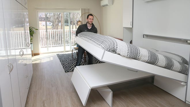Tim Gokhman, the developer, shows how the bed unfolds out of the wall over the dining table at theRhythm apartments.