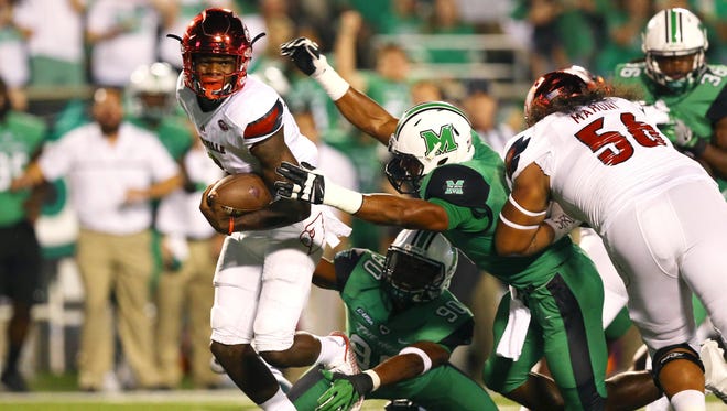 Louisville Cardinals quarterback Lamar Jackson (8) is tackled by Marshall Thundering Herd linebacker Chase Hancock (right) in the first half at Joan C. Edwards Stadium.