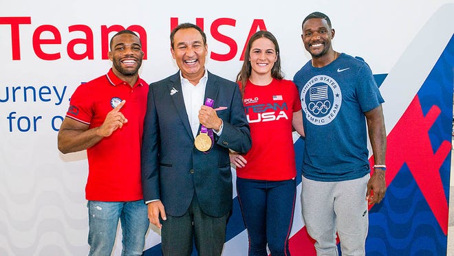 United Airlines CEO Oscar Munoz (second from left) greets (from left) wrestler Jordan Burroughs, wrestler Adeline Gray, and track and field athlete Justin Gatlin at a send-off for members of the U.S. Olympic team at Houston Bush Intercontinental on Aug. 3, 2016.