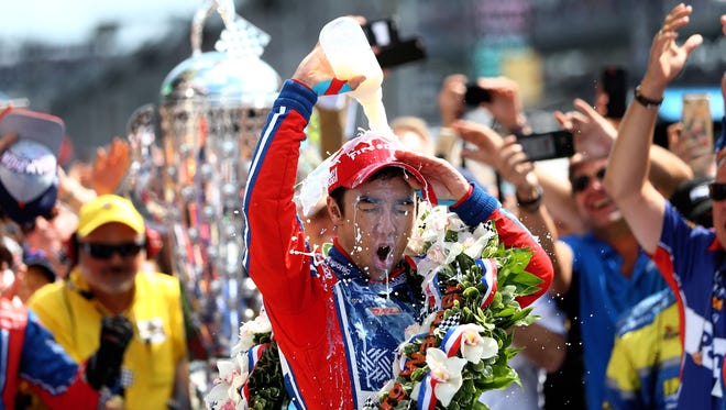 Takuma Sato dumps milk on himself as he celebrates after winning the 101st running of the Indianapolis 500.
