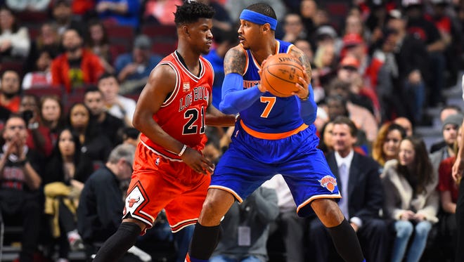 New York Knicks forward Carmelo Anthony controls the ball as Chicago Bulls guard Jimmy Butler defends during the first half at the United Center.