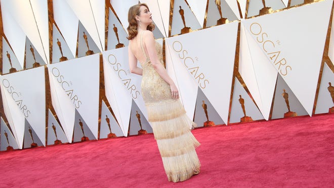 Lights! Cameras! Action! Emma Stone is golden on the red carpet during the 89th Academy Awards at Dolby Theatre.