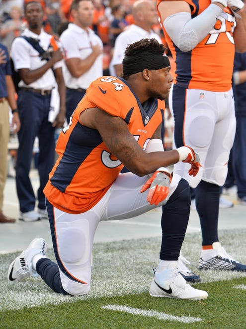 Brandon Marshall kneels for the anthem before the season opener. Marshall has lost two sponsorship deals due to his protest.