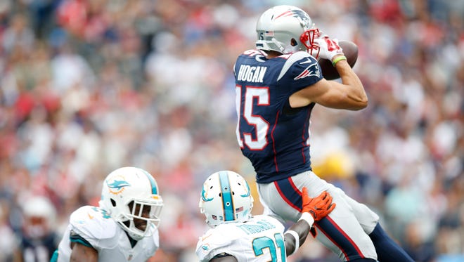 Patriots receiver Chris Hogan (15) makes a leaping catch against Dolphins defender Michael Thomas (31) during the first half.