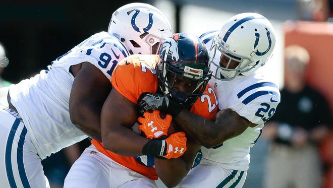 Colts defenders Hassan Ridgeway (91) and Patrick Robinson (25) bring down Broncos running back C.J. Anderson (22) on a first-half carry.
