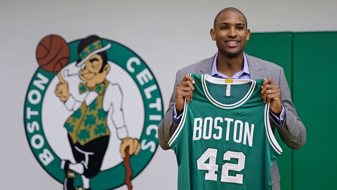 Boston Celtics forward Al Horford holds up a jersey during a media availability at the team's practice facility, Friday, July 8, 2016, in Waltham, Mass.