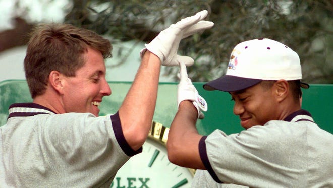 Phil Mickelson and Tiger Woods high five during practice at the Valderrama golf course in southern Spain in 1997.