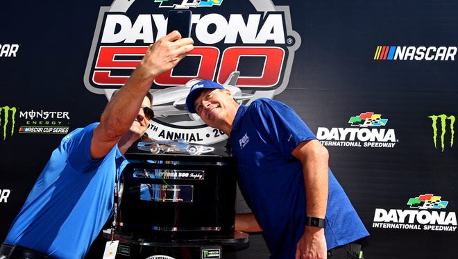 NASCAR Cup Series driver Michael Waltrip (15) takes a selfie with the Harley J. Earl Trophy before the 2017 Daytona 500.