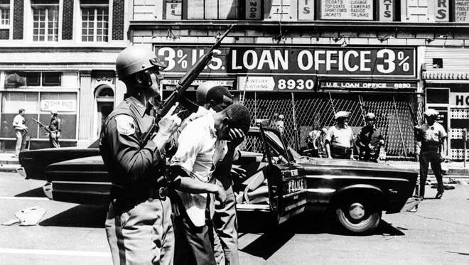 Policemen arrest black suspects on a Detroit street on July 25, 1967 during riots that erupted in Detroit following a police operation.