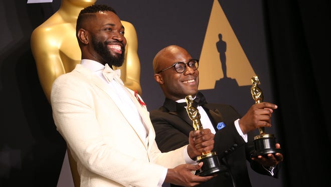 Tarell Alvin McCraney, left, and Barry Jenkins pose with the Oscars for Best Adapted Screenplay for 'Moonlight' in the Academy Awards trophy room.