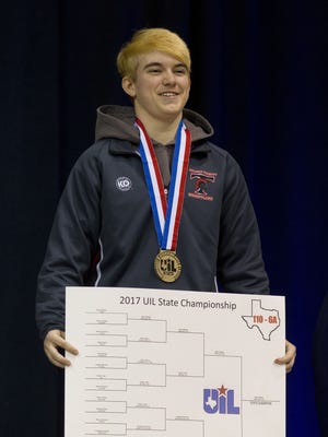 Euless Trinity's Mack Beggs holds a poster with the bracket, after defeating Morton Ranch's Chelsea Sanchez in the girls' Class 6A final at 110 pounds in the state wrestling championships Saturday, Feb. 25, 2017, in Cypress, Texas.