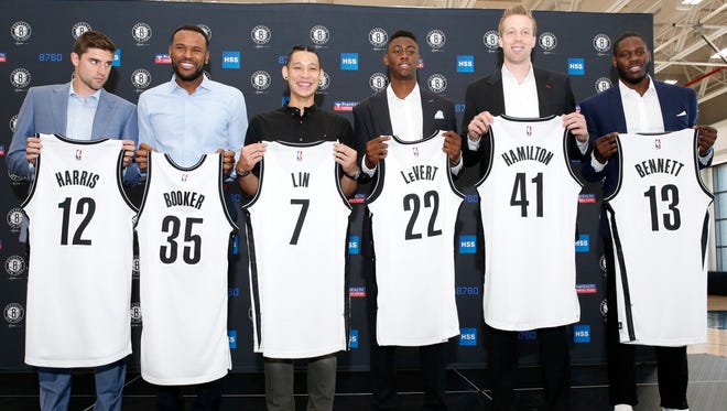 Brooklyn Nets new NBA basketball players pose with their jerseys following a press conference to introduce them, Wednesday, July 20, 2016, at the team's training center in the Brooklyn borough of New York.