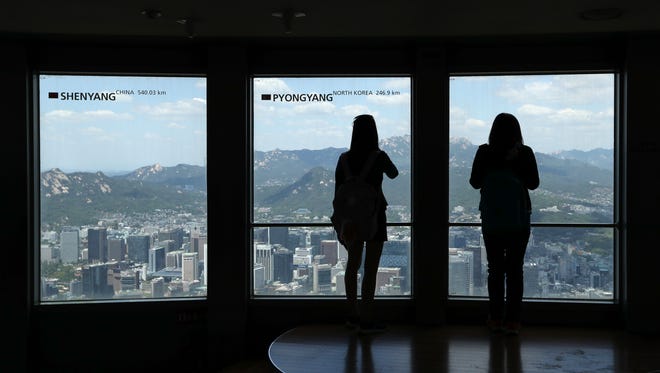Visitors tour near the window with a sign "Pyongyang" at the N Seoul Tower in Seoul, South Korea, Friday, May 26, 2017.