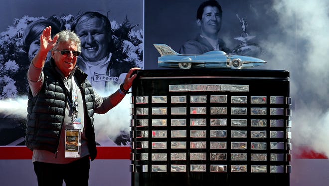Mario Andretti, the 1967 Daytona champion, poses with the Harley J. Earl Trophy, given to the winner of the "Great American Race."