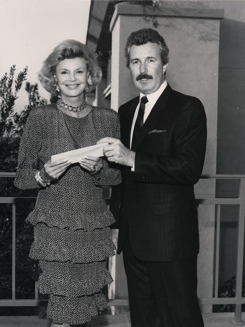 Barbara Sinatra receives a $15,000 check from Ken Rizotto for the Barbara Sinatra Children's Center.