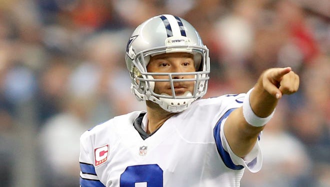 Dallas Cowboys quarterback Tony Romo (9) points to a defender in the game against the Houston Texans at AT&T Stadium.