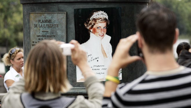 People gathered at the shrine in memory of the late Diana, Princess of Wales, above the Pont de l'Alma tunnel in Paris.