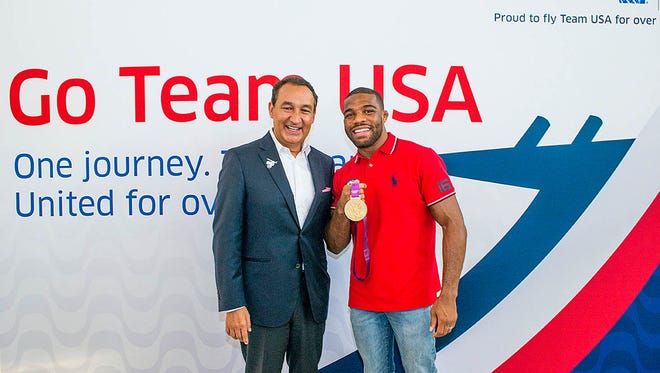 United Airlines CEO Oscar Munoz (left) greets U.S. wrestler Jordan Burroughs at a send-off for members of the U.S. Olympic team at Houston Bush Intercontinental on Aug. 3, 2016.