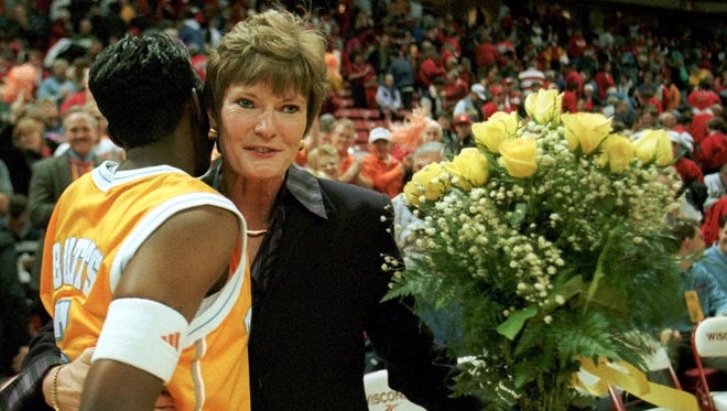 Tennessee's Niya Butts gives Summitt a hug and a bouquet of flowers after Summitt's 700th career victory — a 85-62 win over Wisconsin — in Madison, Wisc.