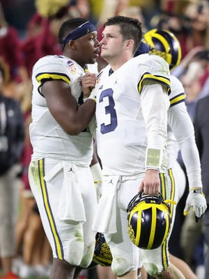 Michigan quarterback Wilton Speight, right, and tight end Tyrone Wheatley walk off the field after losing in the Orange Bowl, 33-32, to Florida State on Friday, Dec. 30, 2016 in Miami Gardens, Fla.