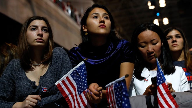 People hold American flags as they watch voting results at Hillary Clinton's election night event in New York City.