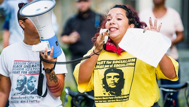 Alissa Ellis speaks to a crowd of protesters gathered in front of a Confederate statue at the old Durham County Courthouse, Monday, Aug. 14, 2017, in Durham, N.C. Protesters in North Carolina toppled a nearly century-old statue of a Confederate soldier Monday at the rally against racism. The Durham protest was in response to a white nationalist rally held in Charlottesville, Va., over the weekend. (Casey Toth/The Herald-Sun via AP)