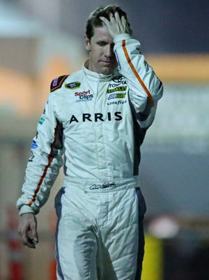 Carl Edwards (19) walks to the infield care center after a wreck during the Ford Ecoboost 400 at Homestead-Miami Speedway.