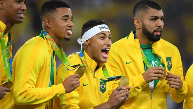 Brazil players celebrate on the podium after defeating Germany in the men's gold medal match during the Rio 2016 Summer Olympic Games at Maracana.
