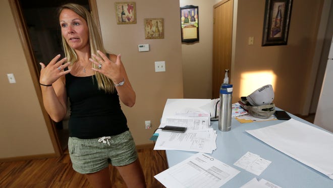 Heidi Sorrem stands near the assortment of medical receipts and paperwork she's collected as a result of her injuries she sustained while on a vacation trip to Mexico where her and her husband both became ill and blacked out after having a couple of drinks and two shots each.