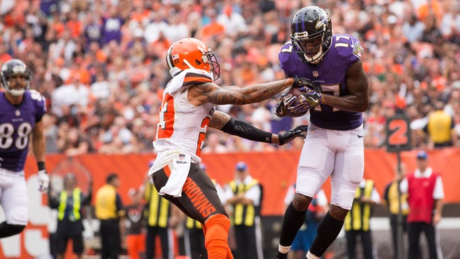 Ravens receiver Mike Wallace (17) hauls in a first-half touchdown catch against Browns defender Joe Haden (23).