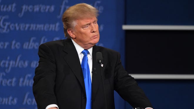 Republican presidential candidate Donald Trump listens on stage during the first presidential debate at Hofstra University.