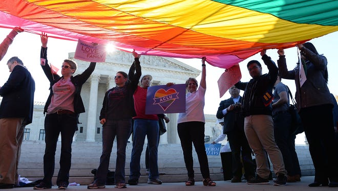 Gay marriage advocates hold a rainbow flag in front of the Supreme Court as arguments began in a collection of same-sex marriage cases in 2015.