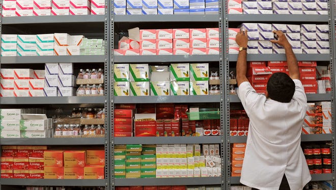 In this photograph taken on June 28, 2012, an Indian pharmacist pulls out a box of medicines from a shelf at a generic drug store at the Victoria Hospital in Bangalore.