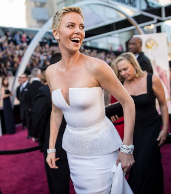 Smile, Charlize! The " Snow White and the Huntsman " star walked the red carpet in a white silk Dior gown at the 2013 Oscars.