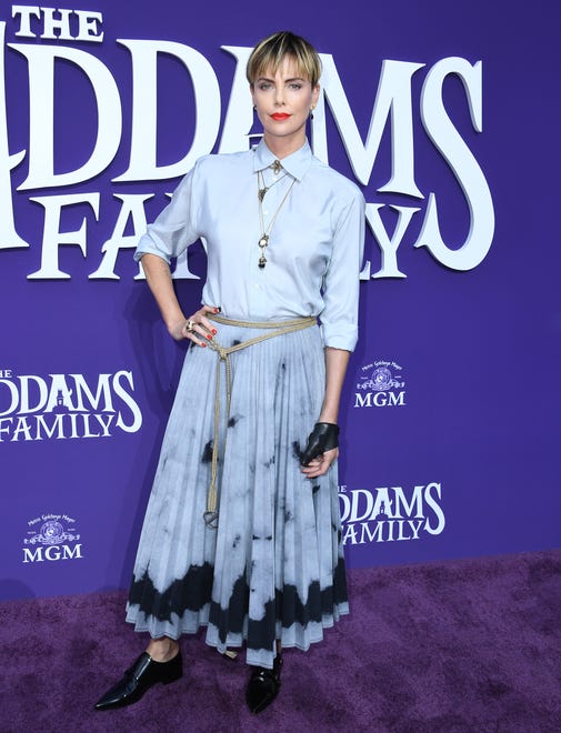 Leave it to Theron to make a bowl cut look chic. She ' s looking animated in her baby blue Dior look at the premiere of " The Addams Family " in 2019.